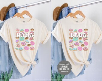 May include: Two ivory t-shirts with donut graphics. The left shirt says "MAMA" and the right shirt says "DADA".
