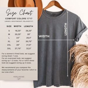 May include: Size chart for a unisex t-shirt in Comfort Colors 1717 fabric. The chart shows the width and length measurements in inches for sizes S, M, L, XL, 2XL, and 3XL. The chart also includes information about sizing for a fitted look, an oversized look, and a t-shirt dress.