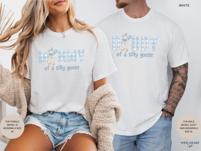 K&ouml;nnte beinhalten: Zwei wei&szlig;e T-Shirts mit einem hellblau-wei&szlig;en Vichy-Karomuster auf den Buchstaben. Das linke T-Shirt zeigt den Text MOMMY of a silly goose mit einer G&auml;nseillustration. Das rechte T-Shirt zeigt den Text DADDY of a silly goose.
