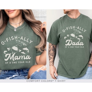 Pu&ograve; includere: Due magliette Comfort Colors verde muschio. Una maglietta dice "O-FISH-ALLY Mama of a One Year Old" con una grafica a tema pesca. L'altra dice "O-FISH-ALLY Dada of a One Year Old".