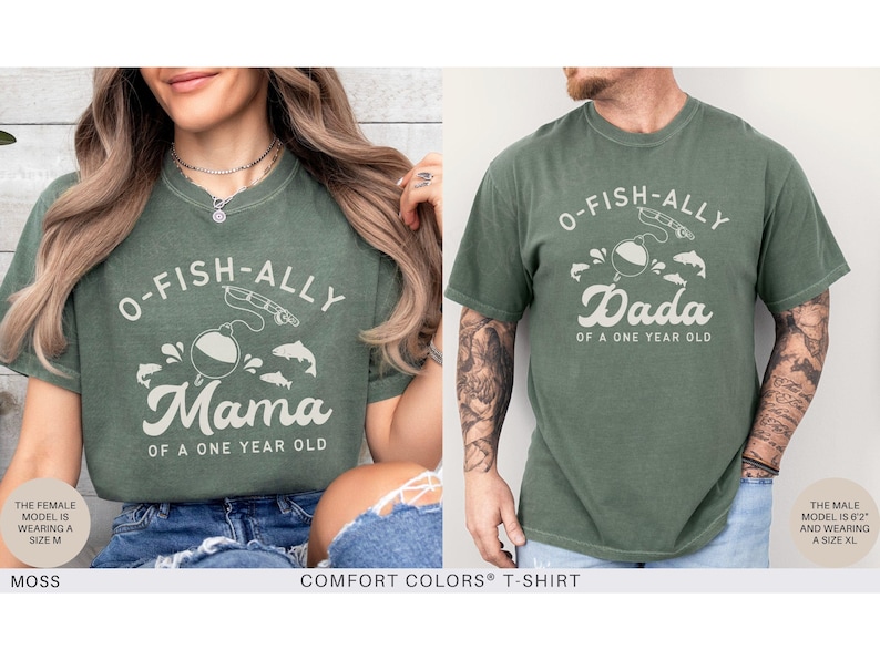 Pu&ograve; includere: Due magliette Comfort Colors verde muschio. Una maglietta dice "O-FISH-ALLY Mama of a One Year Old" con una grafica a tema pesca. L'altra dice "O-FISH-ALLY Dada of a One Year Old".