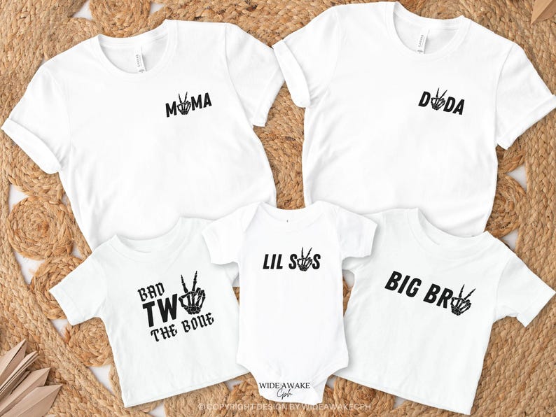 Puede incluir: Un conjunto de cinco camisetas blancas con texto negro y gr&aacute;ficos de signo de paz. Las camisetas dicen "Mama", "Dada", "Lil Sis", "Big Bro" y "Bad Two The Bone".