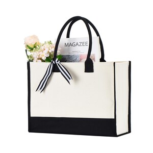 a black and white bag with a flower in it