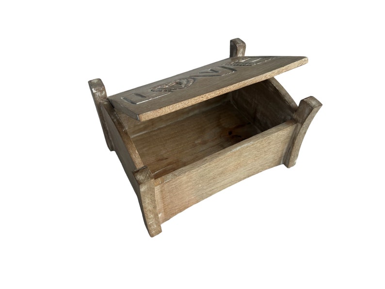 Pu&ograve; includere: Una scatola di legno con un coperchio incernierato. Il coperchio &egrave; aperto e la scatola &egrave; vuota. Il coperchio ha la parola "LOVE" incisa.