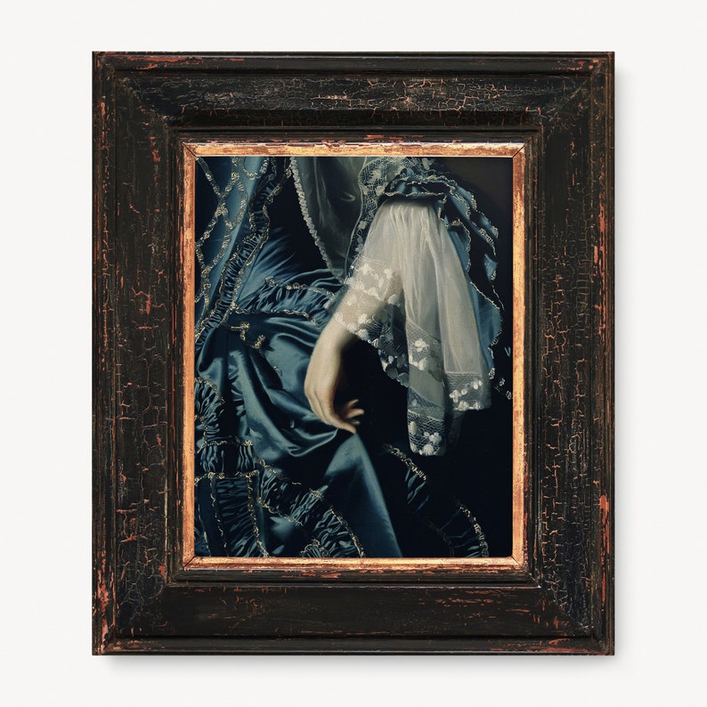 May include: A framed painting of a woman's hand and arm wearing a blue and white dress with lace detailing. The painting is in a dark wood frame with gold accents.