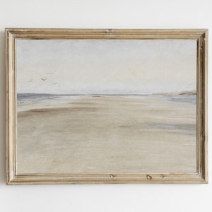 Könnte beinhalten: Ein gerahmtes Gemälde einer Küstenlandschaft mit einem Sandstrand und einem hellblauen Himmel. Das Gemälde ist in einem hellen Holzrahmen.