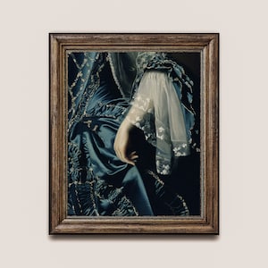 May include: A framed painting of a woman wearing a blue and gold dress with a white lace sleeve. The woman's hand is visible, resting on the dress.