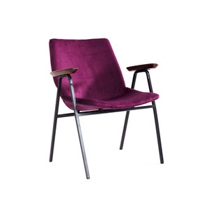 Puede incluir: Un sillón de terciopelo morado con patas de metal negro y reposabrazos de madera.