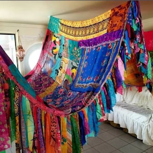 Può includere: Un baldacchino bohémien colorato fatto di ritagli di stoffa e sciarpe colorate. Il baldacchino è appeso al soffitto e crea uno spazio accogliente e intimo.