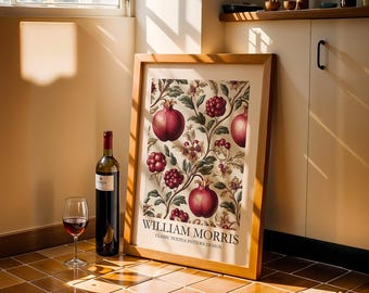 May include: A framed print with a William Morris design featuring pomegranates and berries. A bottle of red wine and a wine glass are next to the frame. The print is in a wooden frame.