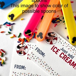 May include: Two blank cards with a Mickey Mouse design and the text "Just add ICE CREAM!" and "FROM:". The cards are surrounded by colorful sprinkles.  There are also four colorful spoons with Mickey Mouse ears on the handles.