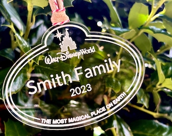 May include: Clear acrylic ornament with a white outline and the text "Walt Disney World" and "Smith Family 2023" with the phrase "The Most Magical Place on Earth" at the bottom.