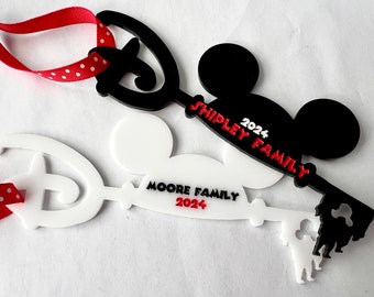 May include: Two white and black Mickey Mouse key ornaments with red ribbon and white polka dots. The white ornament says "Moore Family 2024" and the black ornament says "Shipley Family 2024".