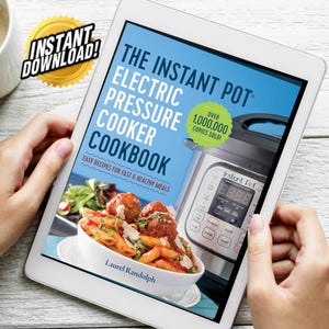 Può includere: Un tablet che mostra la copertina di un libro di cucina intitolato "The Instant Pot Electric Pressure Cooker Cookbook" con uno sfondo blu e una foto di una ciotola di pasta con polpette e una pentola a pressione Instant Pot argentata. Il testo "Over 1,000,000 Copies Sold!" è in un cerchio giallo sulla copertina.