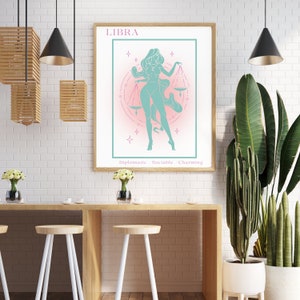 May include: A printable poster featuring a stylized illustration of the Libra zodiac sign. The illustration depicts a woman holding a scale, with a pink and white background and the words "Diplomatic Sociable Charming" at the bottom.