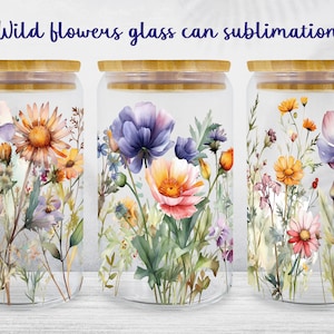Könnte beinhalten: Drei Glasbehälter mit Bambusdeckeln, jeder mit einem anderen Aquarelldesign von Wildblumen. Die Behälter stehen auf einer weißen Holzoberfläche.