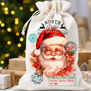 May include: A cream-colored Christmas gift bag with a drawstring closure. The bag features a festive illustration of Santa Claus, the text "North Pole Special Delivery," and various holiday-themed stamps and designs. The bag is filled with gifts.