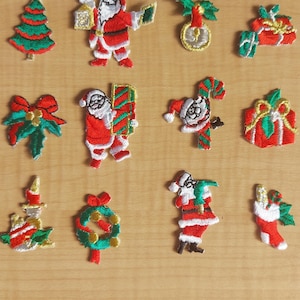 May include: Embroidered Christmas patches in various designs. The collection includes a Christmas tree, Santa Claus figures, gifts, wreaths, and candles. Patches are red, green, white, and gold, ideal for festive crafts and decorations.