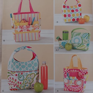 May include: Simplicity pattern 1385 for various tote bags and pouches. The cover displays designs A, B, C, D, E, and F, featuring colourful floral, striped, and paisley fabric patterns. Each bag style includes handles or ties, with some showing exterior pockets.