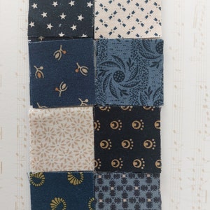 May include: Nine fabric squares in various shades of blue and beige with different patterns, including stars, leaves, and geometric shapes.