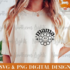 Op de afbeelding: Een wit T-shirt met een zwart grafisch ontwerp van een bloem met een smiley-gezicht en het woord "mama" in een retro-lettertype.
