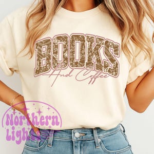 K&ouml;nnte beinhalten: Cremefarbenes Sweatshirt mit dem Schriftzug "BOOKS And Coffee" in brauner, floral gef&uuml;llter Schrift. Der Text ist dunkelbraun umrandet. Das Sweatshirt wird mit einer blauen Jeans kombiniert.