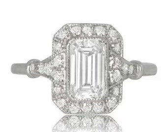 May include: A silver engagement ring with a large, clear emerald-cut diamond set in a halo of smaller diamonds.