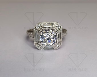 May include: A silver engagement ring with a large, round, clear center stone surrounded by smaller, clear stones. The ring has a square-shaped halo setting with a decorative band.
