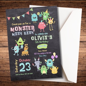 May include: A black chalkboard-style invitation for a "Monster Mash Bash" birthday party. The invitation features colorful monster illustrations, the text "Olivia's 5th Birthday," and event details. A white envelope is partially visible.