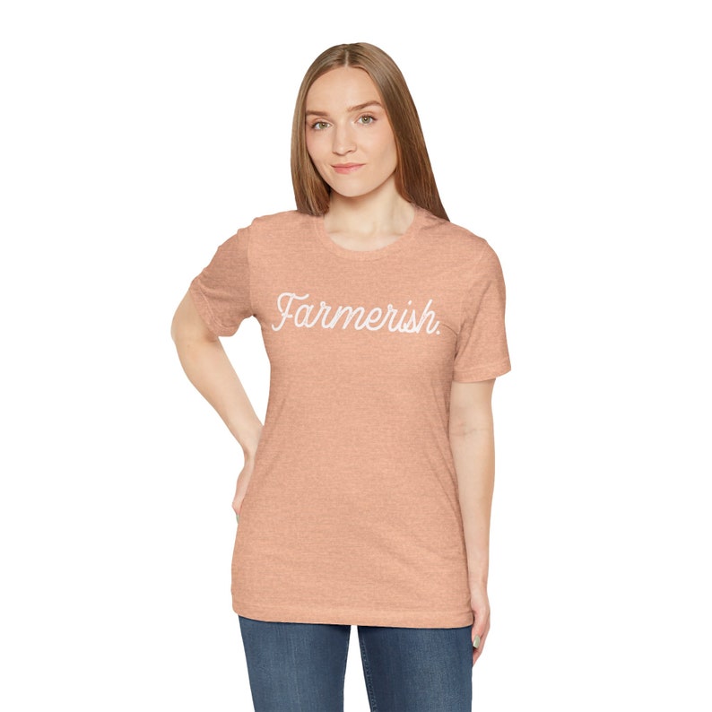 May include: A peach-colored t-shirt with the text "Farmerish" in white cursive lettering.