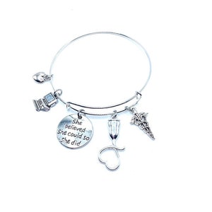May include: Silver charm bracelet with a heart, computer, medical symbol, and a charm that says "She believed she could so she did".