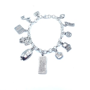 May include: A silver charm bracelet with various charms, including a computer keyboard, a mouse, a heart with the word "cookie" on it, a phone, an email symbol, and a ladybug.