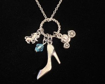 May include: Silver necklace with a glass blue crystal, a silver shoe charm, a silver carriage charm, and a silver dog charm.