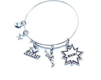 May include: Silver charm bracelet with a heart, star, karate, and BAM! charms.