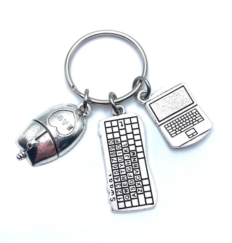 May include: Silver keychain with three charms: a computer mouse with a heart that says "I love", a keyboard with the letters and numbers, and a laptop computer.