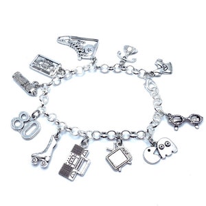 May include: A silver-toned charm bracelet featuring various miniature pendants including a high-top sneaker, cassette tape, hairspray can, the number 80, a roller skate, a boombox, a television, a ghost, a pair of glasses, and a telephone.