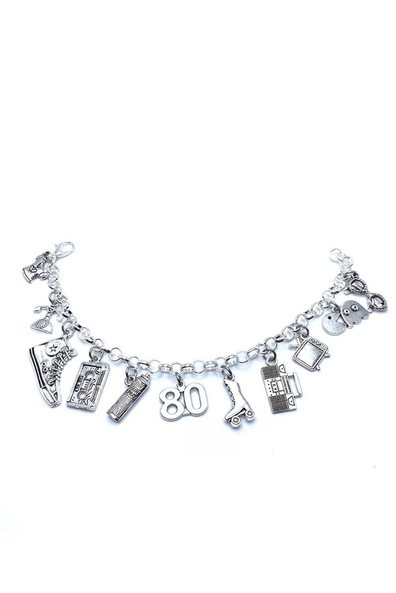 May include: A silver-toned charm bracelet featuring various miniature pendants including a high-top sneaker, a cassette tape, a hairspray bottle, the number 80, a roller skate, a boombox, a television, a ghost character, and a rotary telephone.