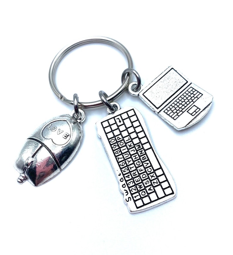 May include: Silver keychain with three charms: a computer keyboard, a laptop, and a computer mouse with a heart that says "Love Me".