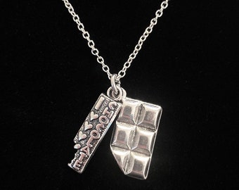May include: A silver necklace with a charm that says "I ♥ Chocolate" and a charm shaped like a chocolate bar.