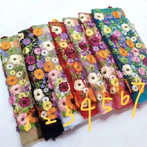 May include: A selection of seven different colored floral embroidered tulle fabrics. The fabrics are arranged in a row, with the numbers 1 through 7 written on the bottom edge of the image.