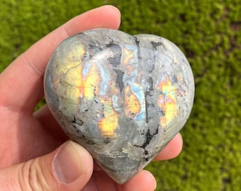 May include: A heart-shaped labradorite crystal with iridescent blue, green, and gold colors. The crystal is polished and smooth.