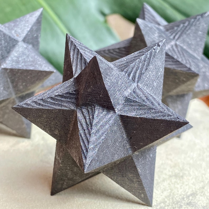 May include: Close-up of several gray, star-shaped decorative objects. Each star has multiple points and a textured surface. The stars are arranged in a group, with some in focus and others blurred in the background.