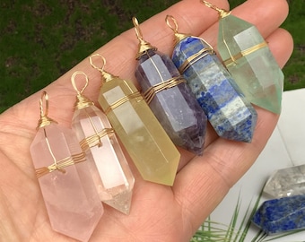 May include: Six different colored crystal point pendants wrapped in gold wire. The crystals are clear, pink, yellow, purple, blue, and green.