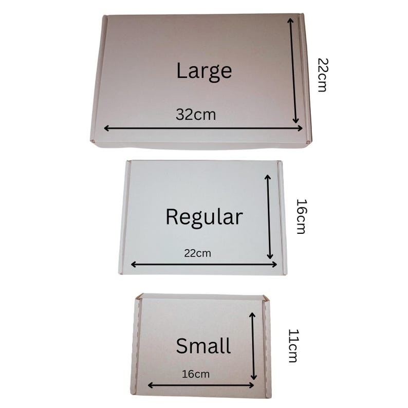 Op de afbeelding: Drie witte kartonnen dozen met de labels "Large", "Regular" en "Small". De "Large" doos meet 32 cm x 22 cm, de "Regular" doos is 22 cm x 16 cm en de "Small" doos is 16 cm x 11 cm. Elke doos heeft duidelijk afmetingen.
