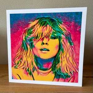 Pop art greeting card featuring Debbie Harry, the iconic lead singer of Blondie, illustrated in bold vibrant retro colors. This 80s music-inspired card captures her punk rock energy and new wave style, making it a perfect gift for Blondie fans, music lovers, and collectors of retro art. Ideal as a birthday card, fan memorabilia, or unique stationery, this Debbie Harry card adds a cool, edgy touch for anyone who loves rock and pop culture.