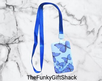 Puede incluir: Lanyard azul con un portagafete de plástico blanco con un patrón de mariposas azules. El texto "TheFunkyGiftShack" es visible en la parte inferior de la imagen.