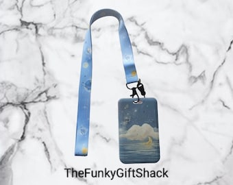 May include: A blue lanyard with a white and blue pattern of planets and stars. The lanyard is attached to a blue and white ID card holder with a moon and cloud design. The text "TheFunkyGiftShack" is printed below the image.