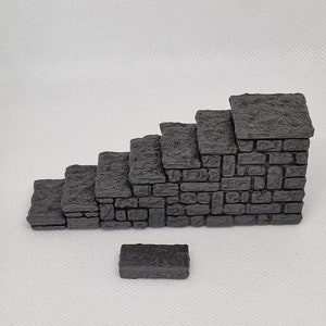 Op de afbeelding: Een set van zes grijze stenen treden met een enkele grijze steenblok. De treden zijn gemaakt van een ruw, getextureerd materiaal en hebben een licht onregelmatig oppervlak.