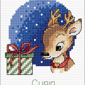 Puede incluir: Un patrón de punto de cruz de un reno de dibujos animados con un lazo rojo y una caja de regalo. El reno lleva un collar rojo con un dije de corazón dorado. El fondo es un cielo nocturno azul con copos de nieve blancos. El texto "Cupid" está escrito debajo del reno.