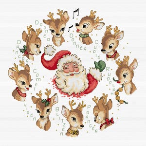 May include: A cross-stitch pattern featuring a central Santa Claus head surrounded by nine reindeer heads arranged in a circle. Each reindeer is labelled with its name: Dasher, Dancer, Prancer, Vixen, Comet, Cupid, Donner, Blitzen, and Rudolph.